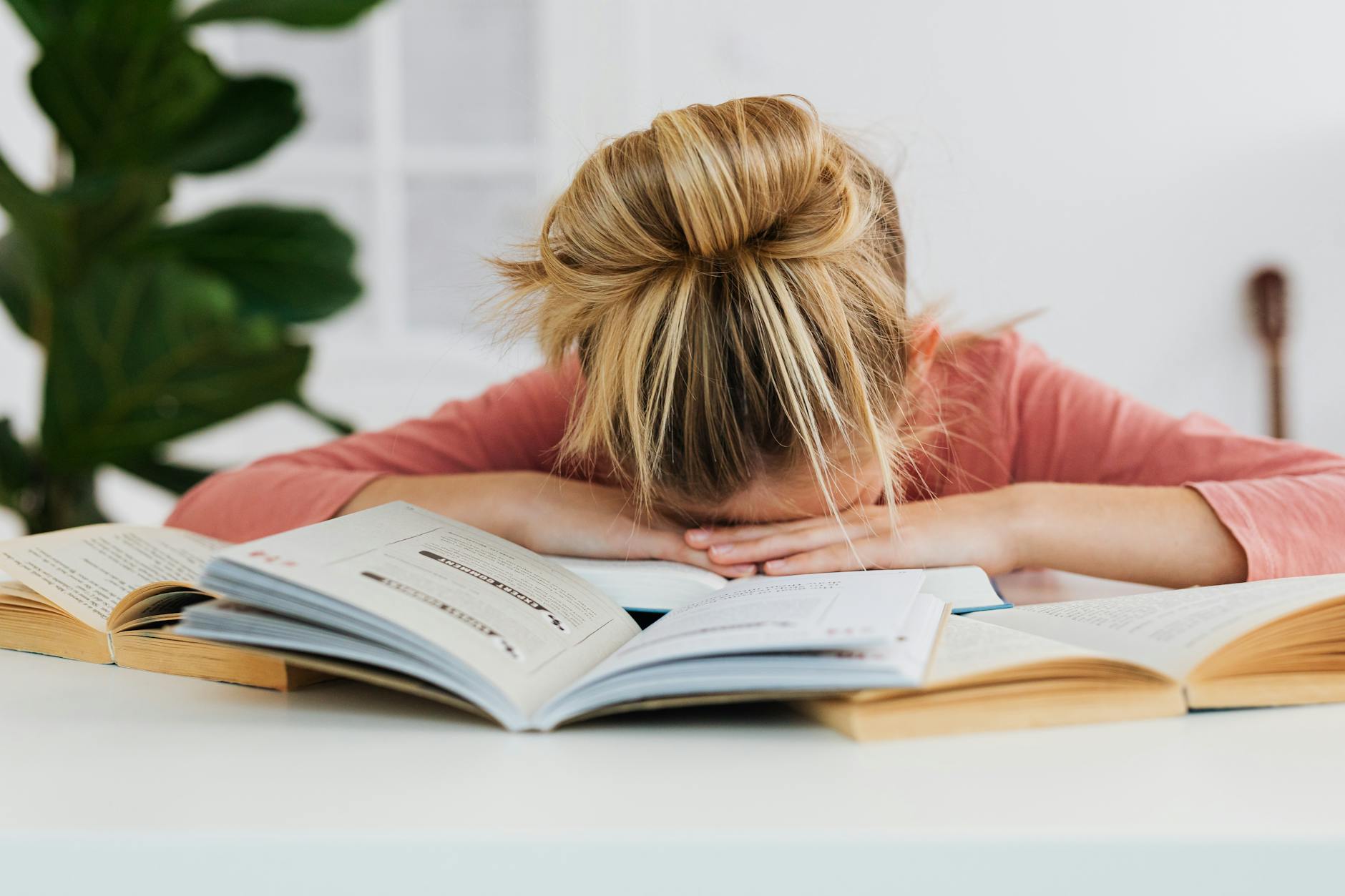 girl sleeping with her head on open books